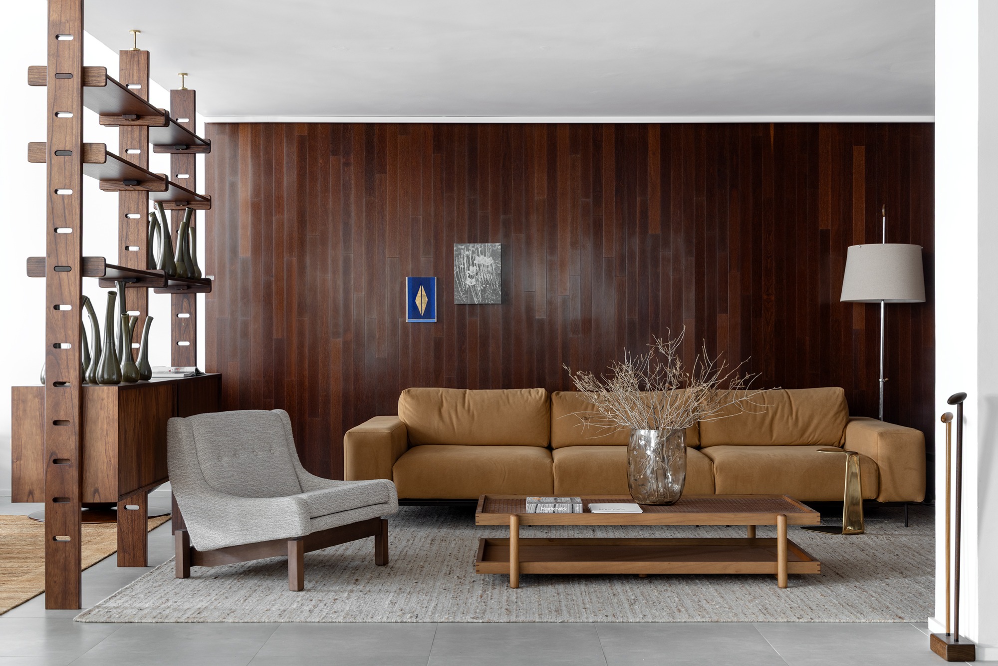 Ambiente com sofá modular, Poltrona Paraty, estante e luminária de piso